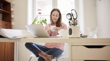 woman sitting at desk in home finding extra money in her budget at year-end