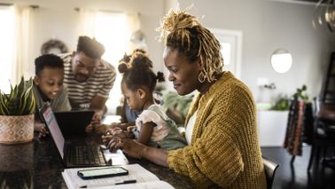 Mom with family in kitchen doing financial planning for families