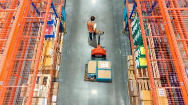 warehouse worker moving items with pallet jack