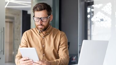 Man reading Northwestern Mutual’s Weekly Market Commentary.