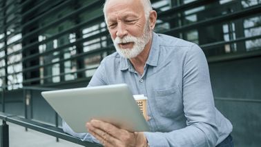 Man drinking coffee and reading Northwestern Mutual Market Commentary